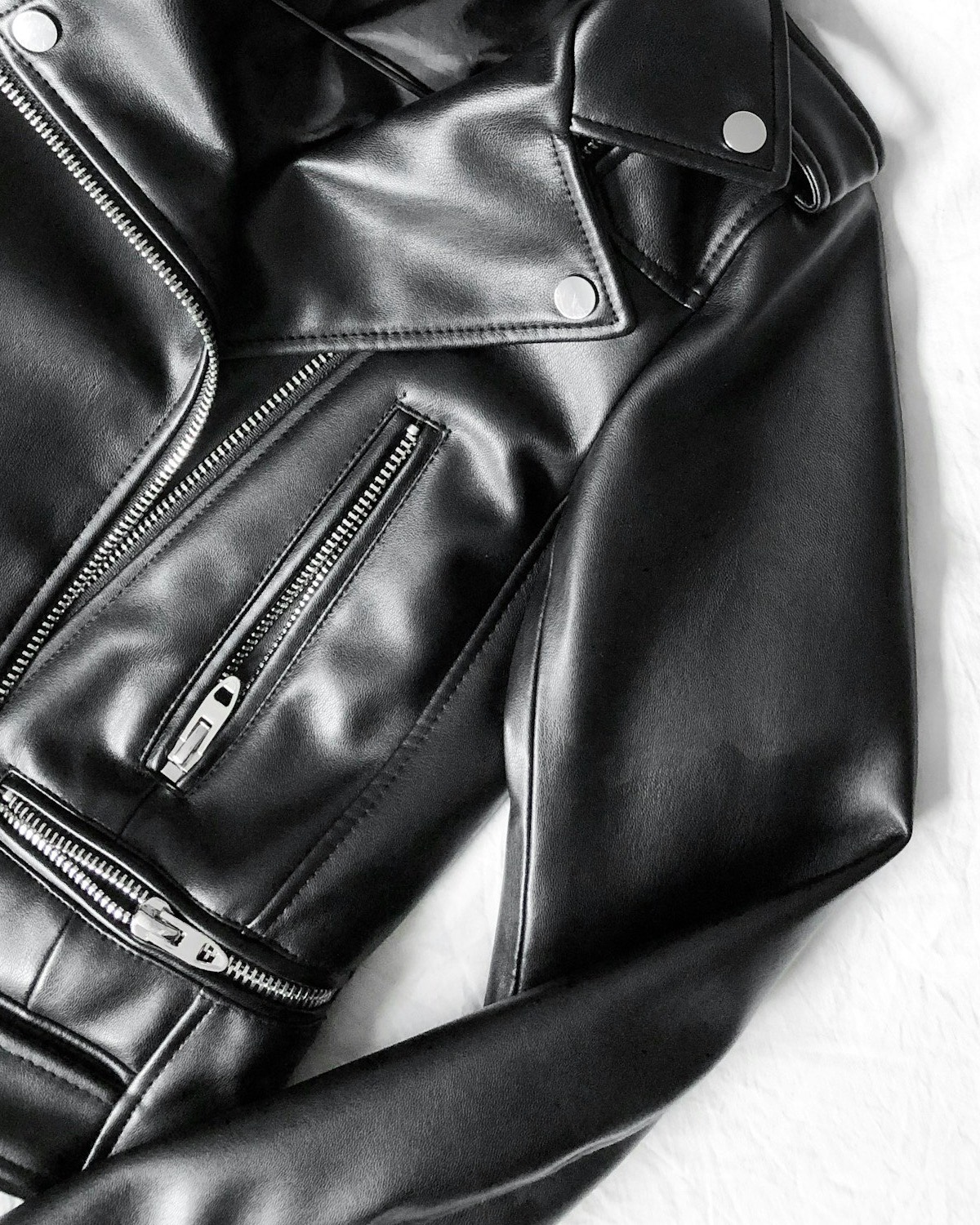 Blouson motard en cuir noir posé à plat
